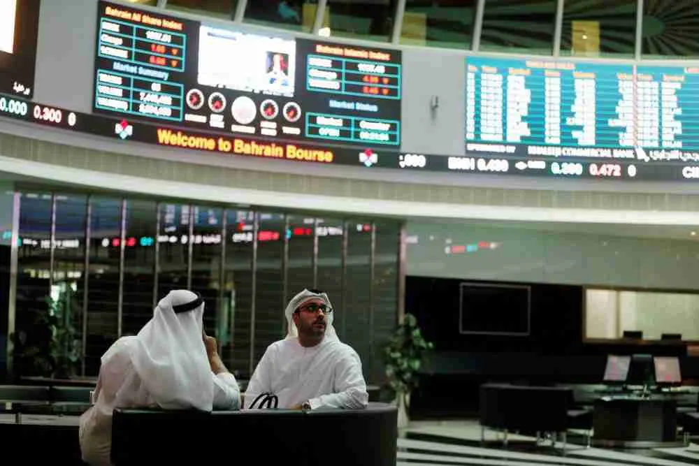 7B3WZV4L45LRLAXMN5MCGTIU6U تجار ينظرون إلى الشاشات في بورصة البحرين في العاصمة البحرينية المنامة، في 7 فبراير 2018. الصورة: حمد بن محمد، لرويترز.
