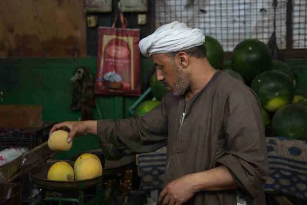 بائع يزن فاكهة في سوق المنهل بالقاهرة. الصورة: إسلام صفوت، لبلومبيرغ.