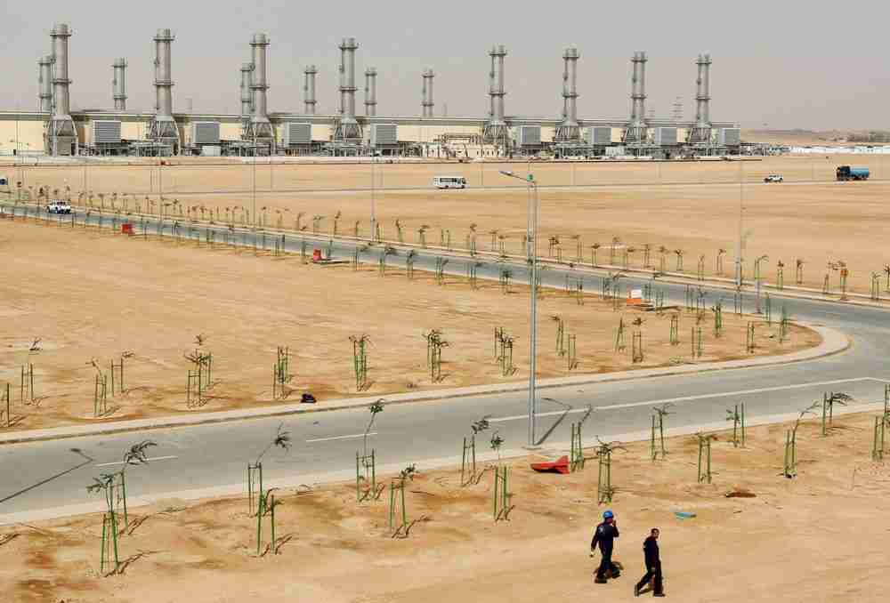 أشخاص يسيرون بالقرب من محطة الطاقة رقم 10 في منطقة العمليات المركزية التابعة للشركة السعودية للكهرباء، جنوب الرياض. الصورة: رويترز