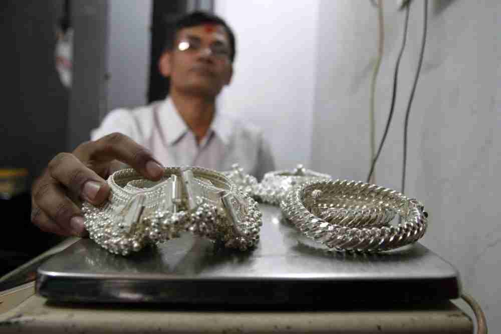 تاجر فضة يزن الحلي الفضية داخل متجره في مدينة أحمد آباد غربي الهند. الصورة: أميت ديف، لرويترز